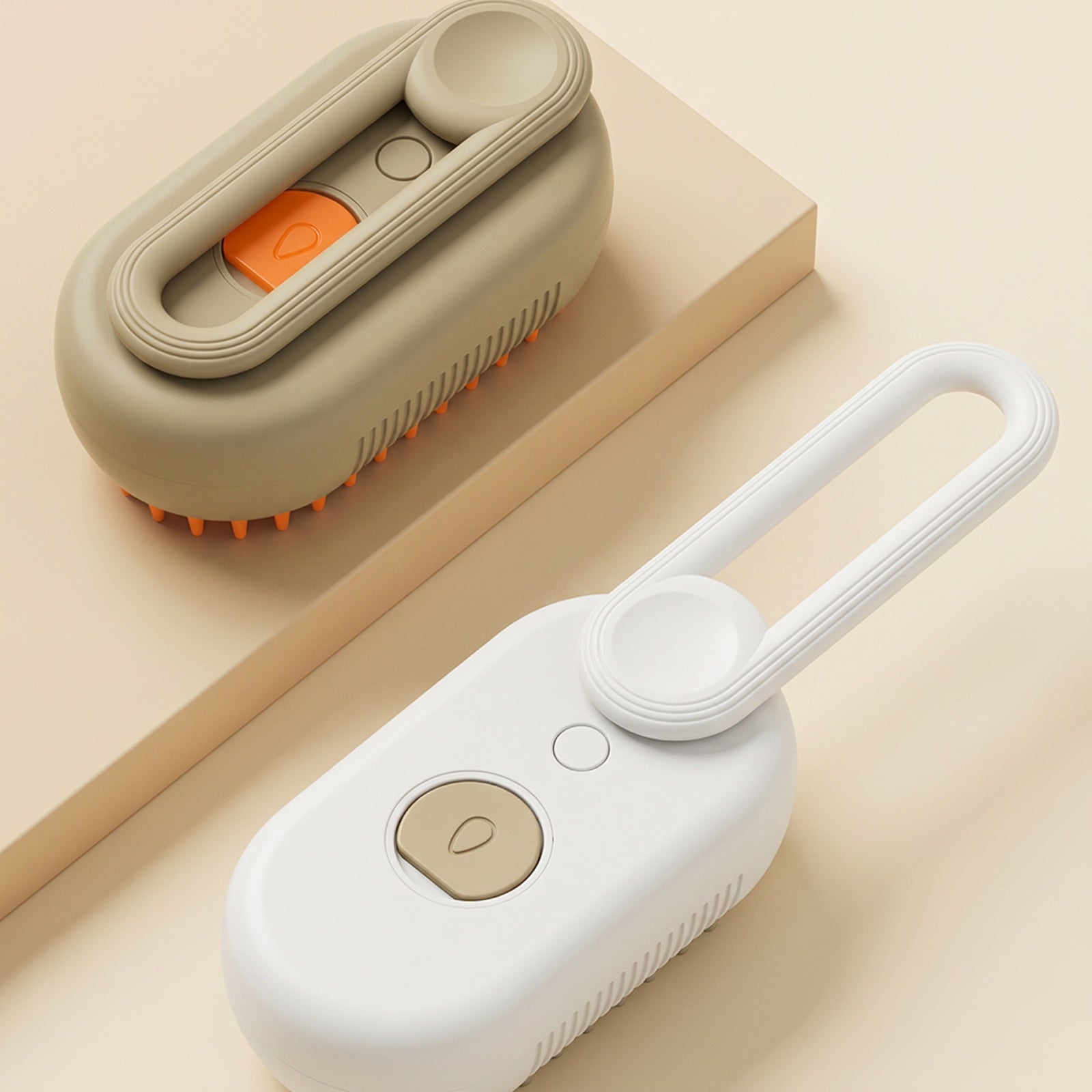 Cat steam brush in khaki and white, one folded flat and one with its loop handle extended, on a warm cream background