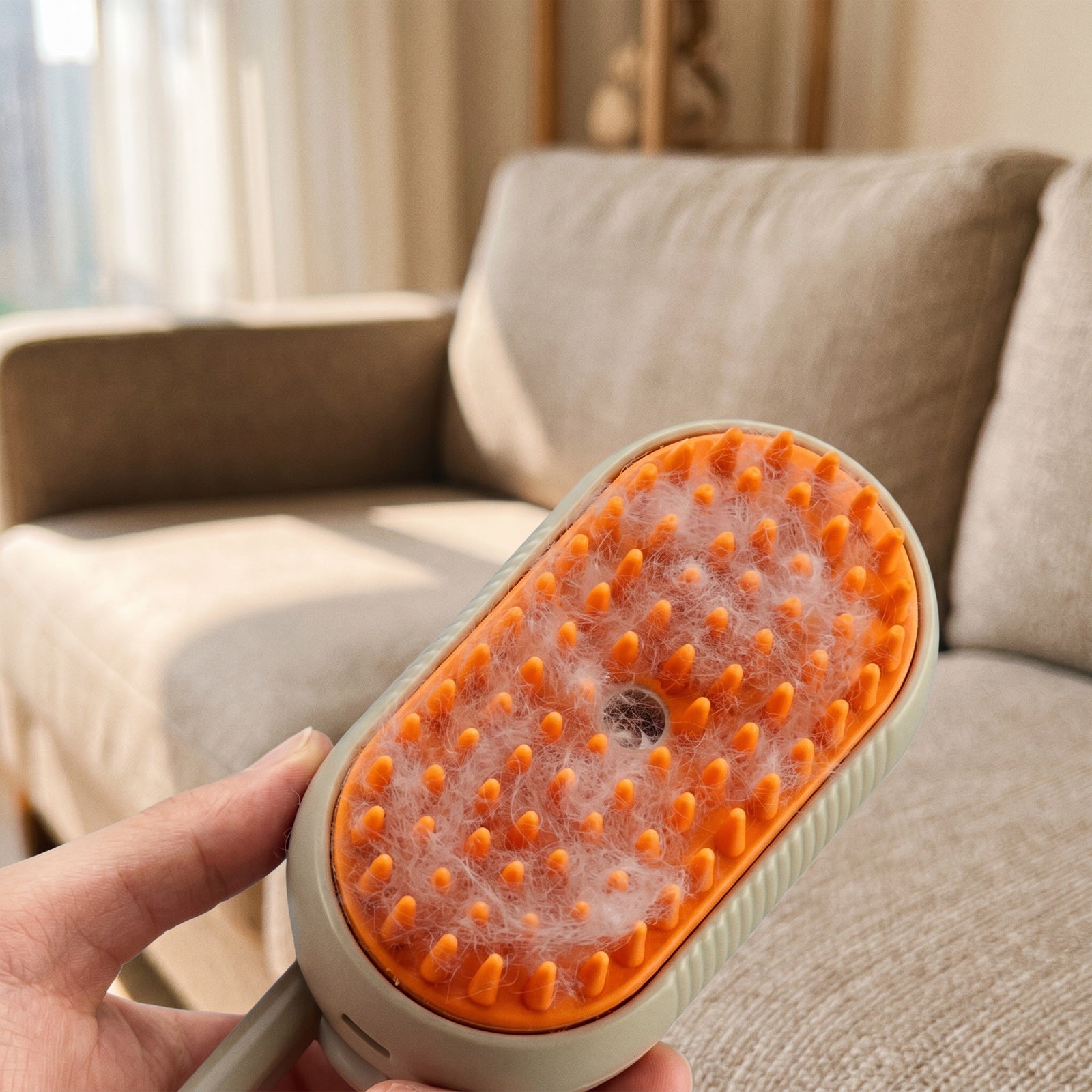 Loose cat fur lifted onto the steam brush bristles in a single pass, held over a sofa